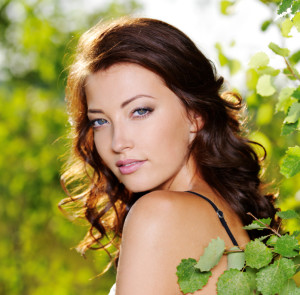 woman looking over her shoulder on a natural green background