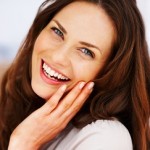 Woman smiling with her hand on her face