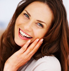Woman smiling with her hand on her face